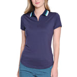 Woman wearing a navy polo shirt and blue patterned pants on a white background